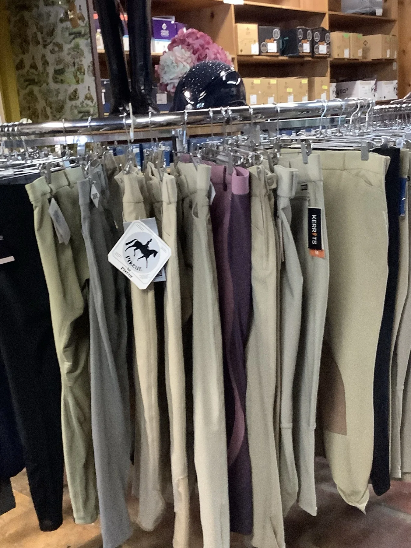 Rack of English riding breeches in tan, olive and plum