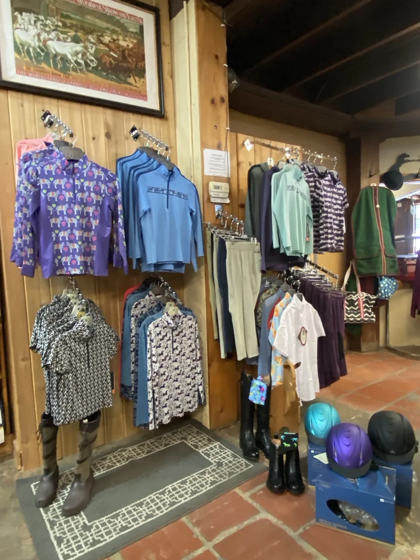 English riding shirts and jerseys on display with helmets and boots nearby