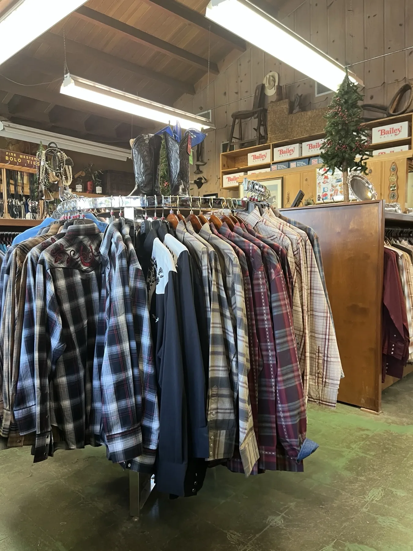 Rack of western shirts with boots displayed above